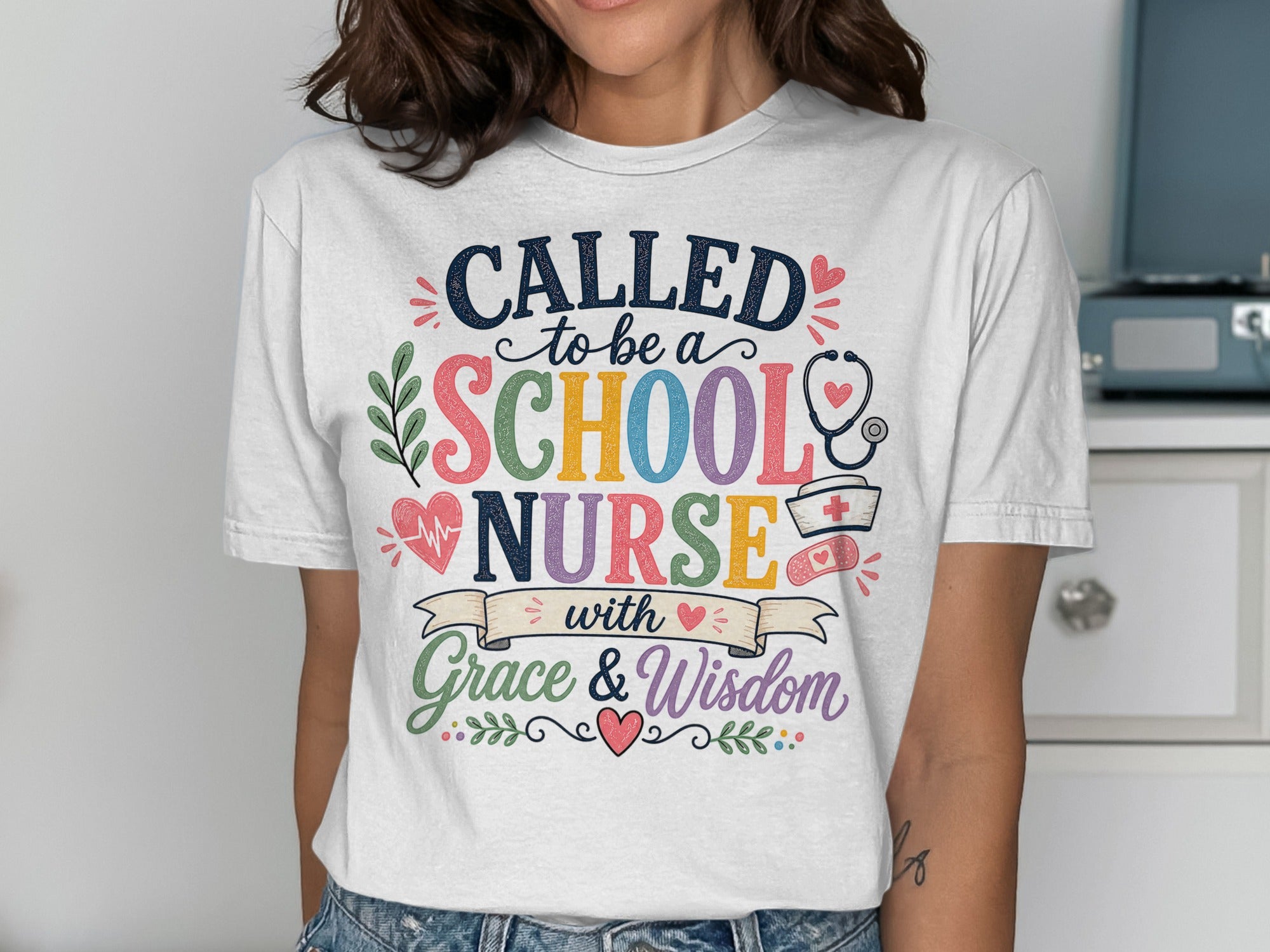 White t-shirt with "Called to be a School Nurse with Grace & Wisdom" slogan and medical graphics.
