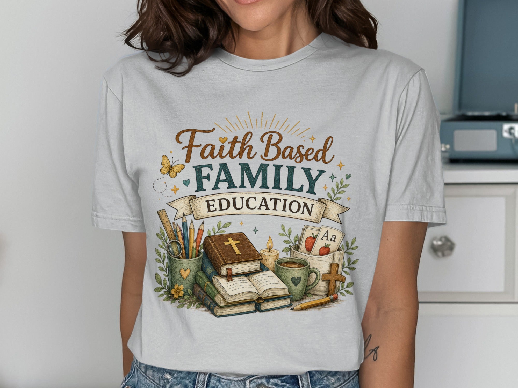 T-shirt graphic with "Faith Family Education" text, books, and school supplies.