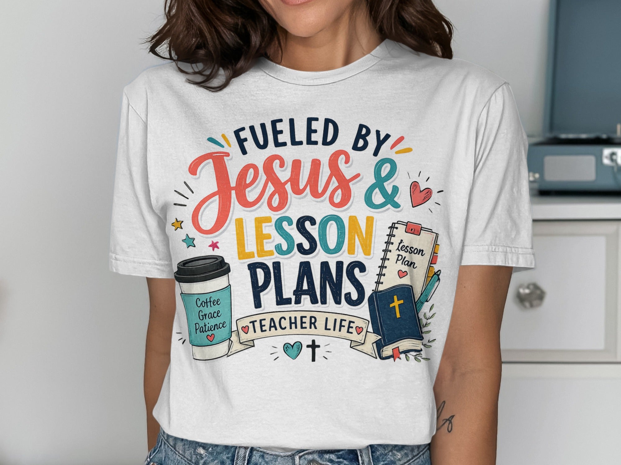 T-shirt with text "Fueled by Jesus & Lesson Plans", featuring coffee and bible icons.