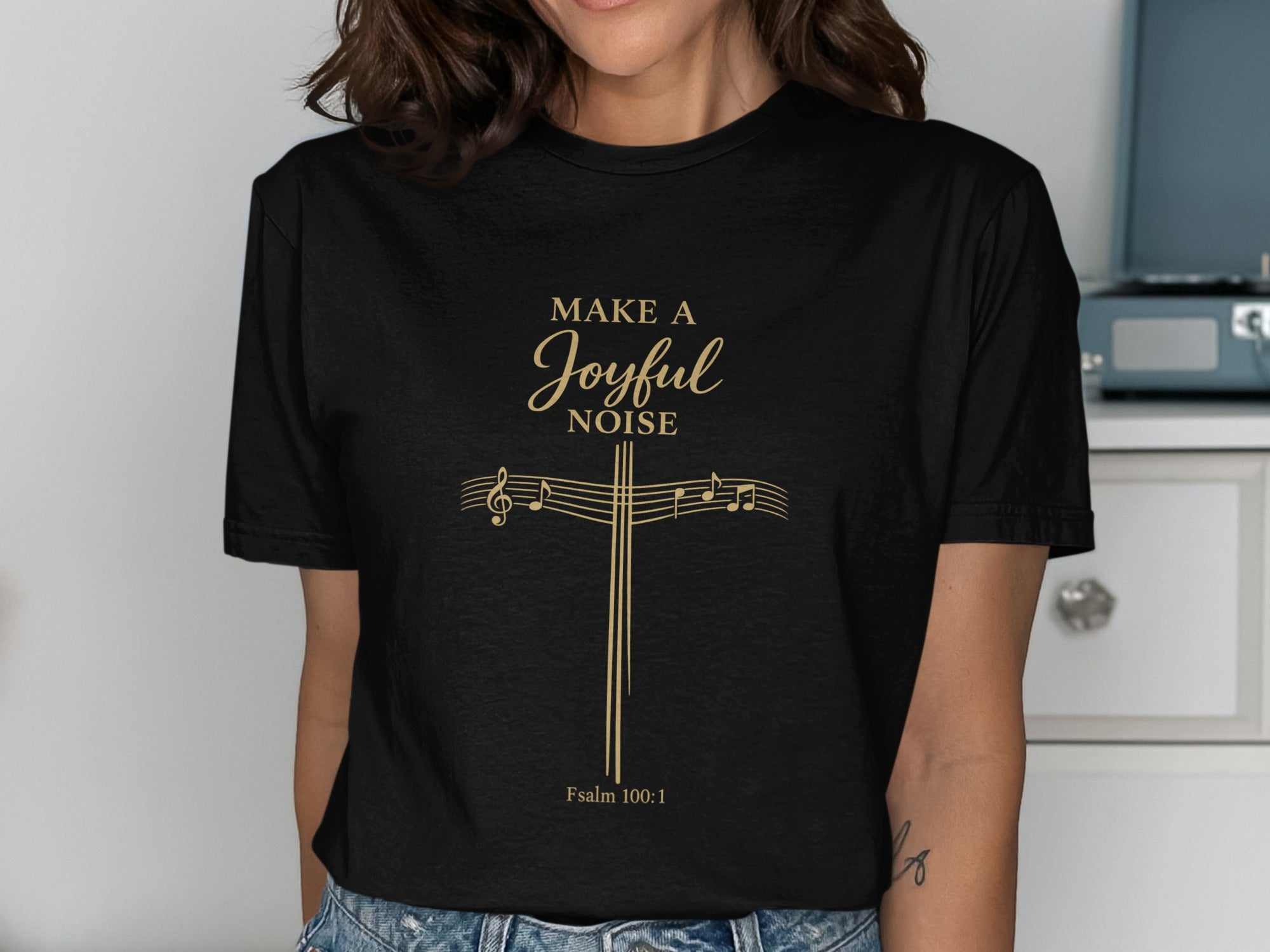 Black t-shirt with gold musical notes forming a cross and "Make a Joyful Noise" text.