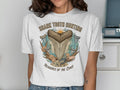 White t-shirt graphic with sharks teeth, shells, and "Shark Tooth Hunting" text.