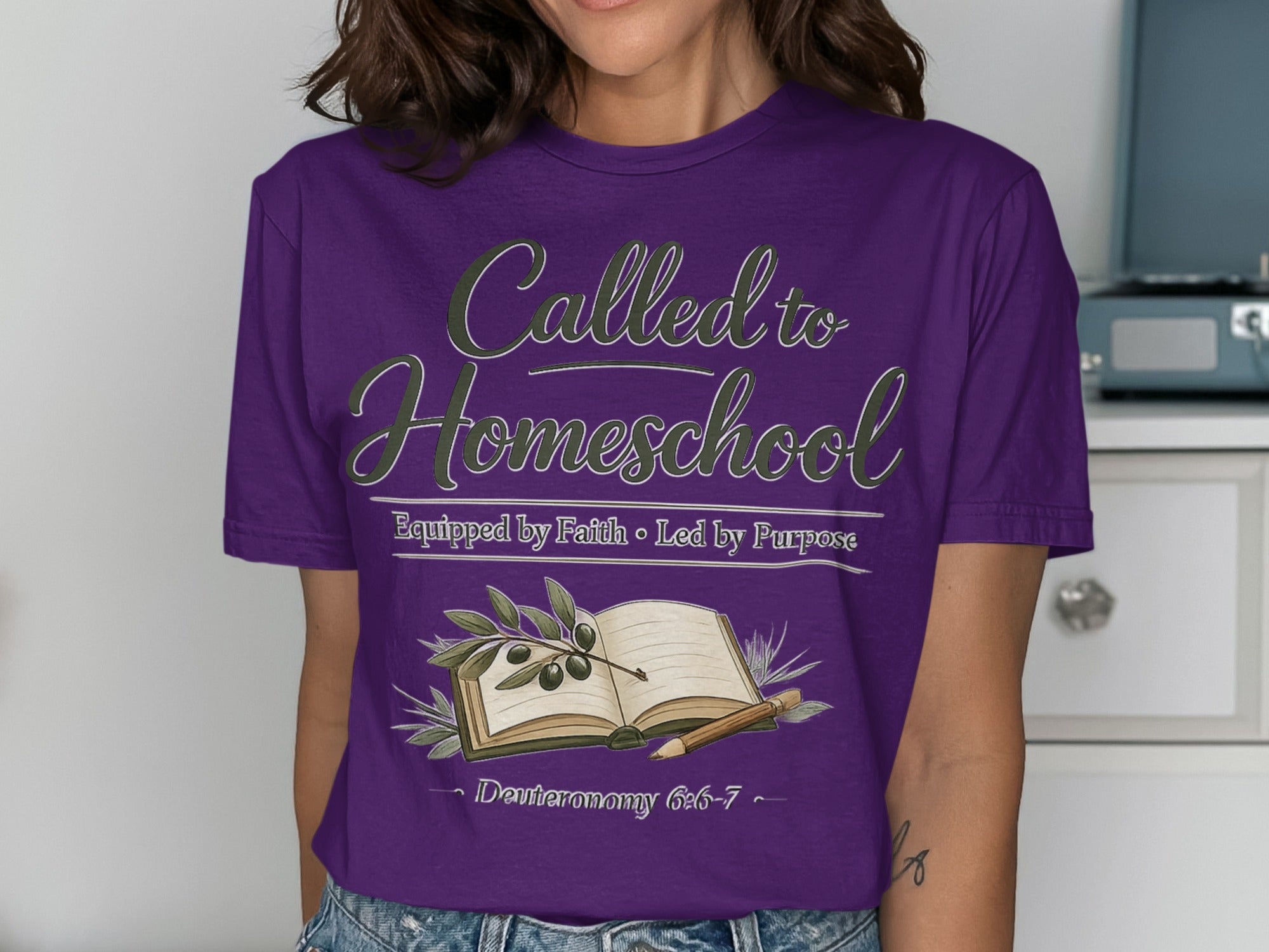 Purple t-shirt with "Called to Homeschool" text, an open book, and olive branches.
