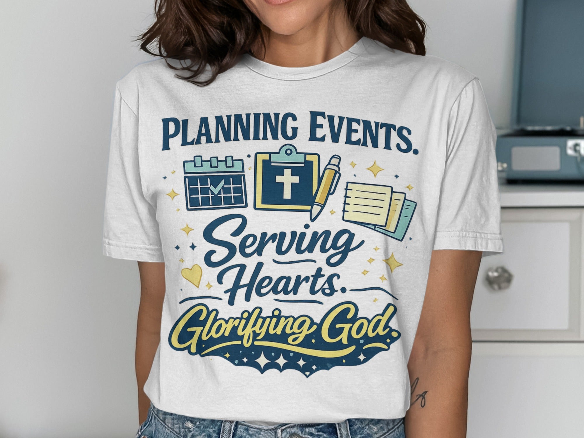 White t-shirt with "Planning Events. Serving Hearts. Glorifying God." text.