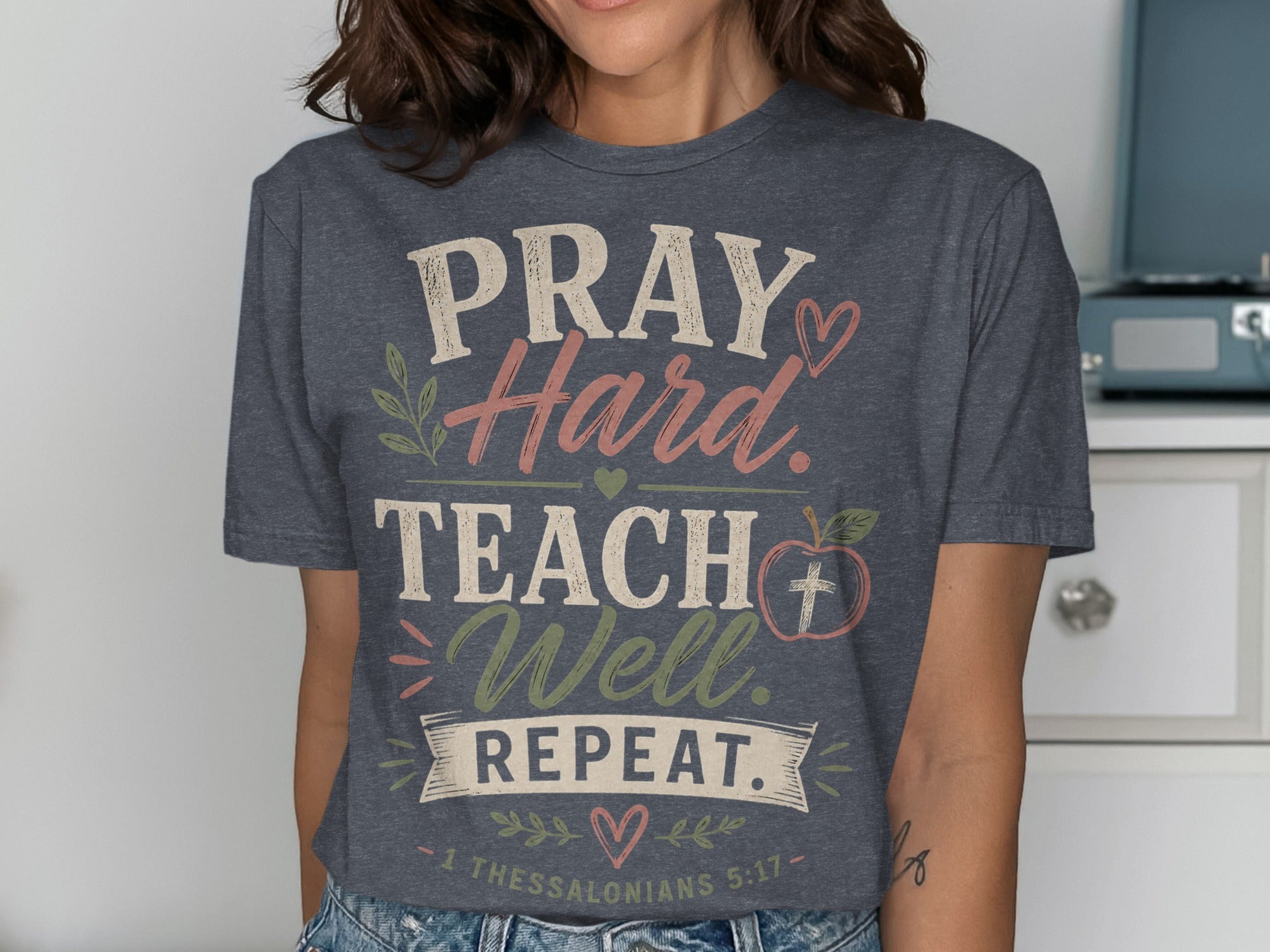 Dark gray t-shirt with PRAY Hard TEACH Well REPEAT text and apple graphic.