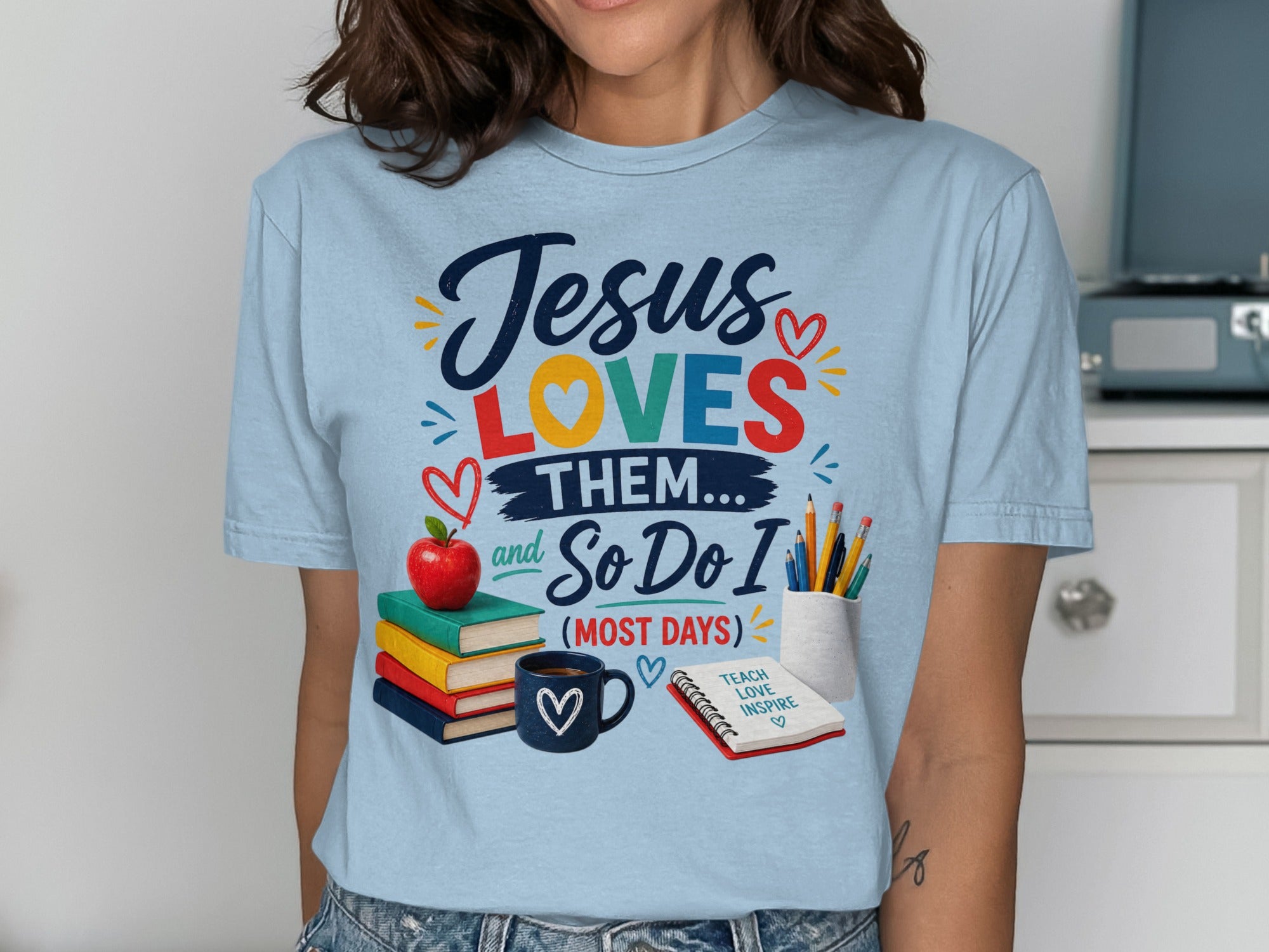 Light blue t-shirt with "Jesus LOVES THEM... and So Do I (MOST DAYS)" and school icons.