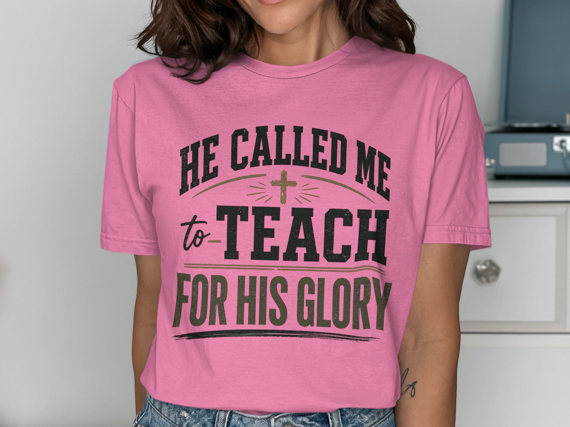 Pink t-shirt with "He called me to teach for His glory" text and a cross.