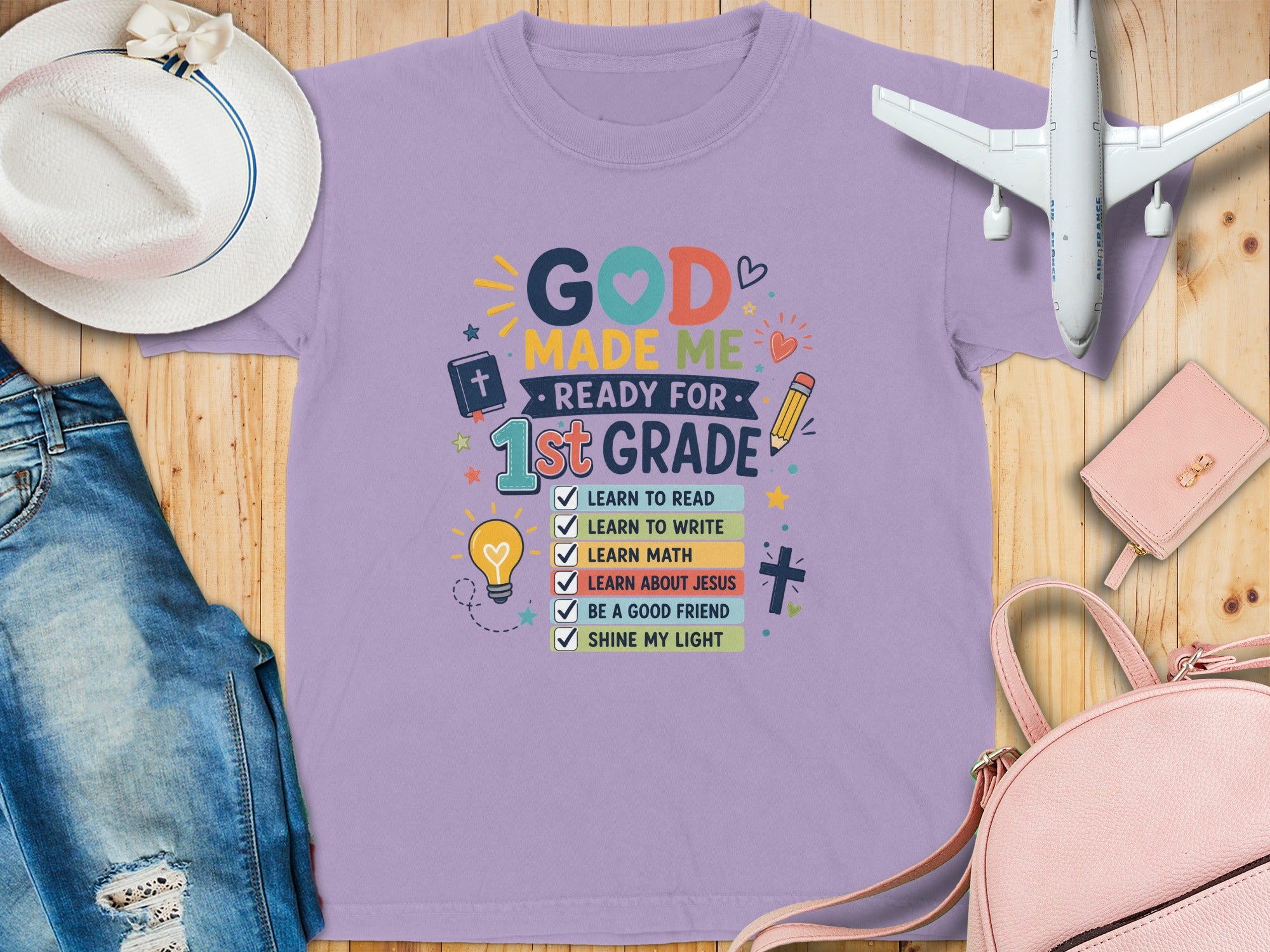 Lavender t-shirt with "God Made Me Ready for 1st Grade" and checklist for school subjects.