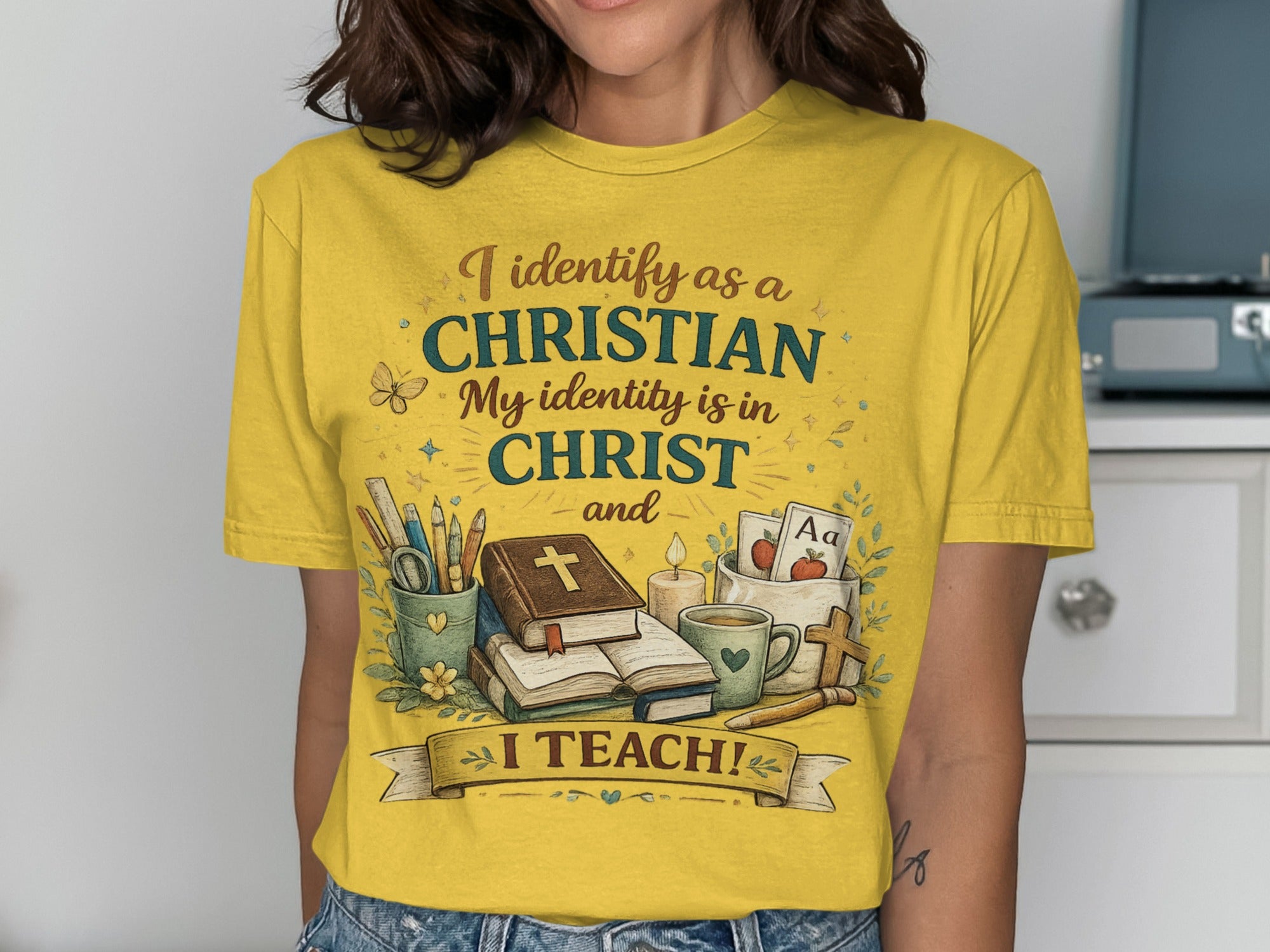 Yellow t-shirt with Christian imagery and text "I identify as a CHRISTIAN My identity is in CHRIST and I TEACH!".