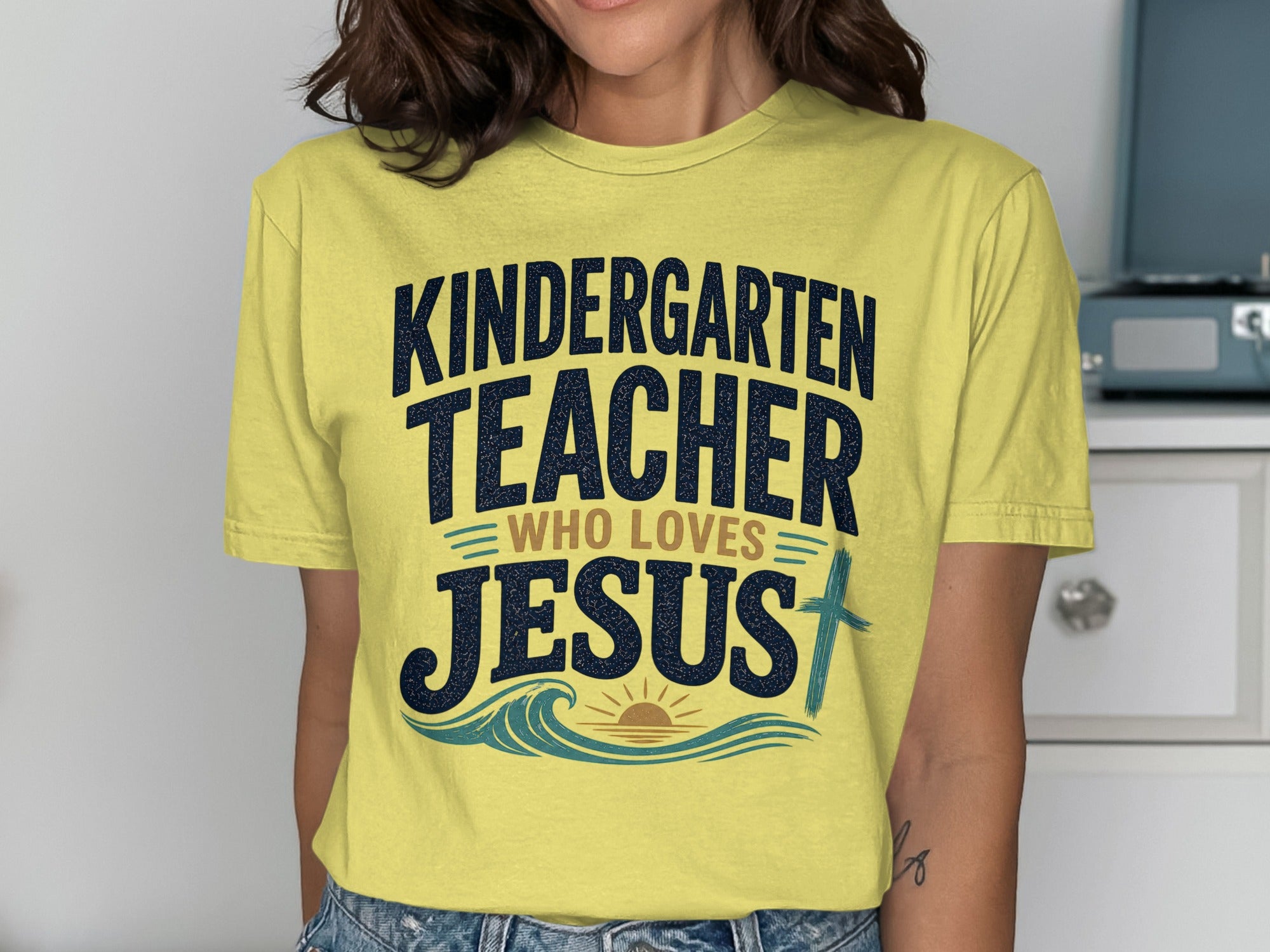 Yellow t-shirt with "Kindergarten Teacher Who Loves Jesus" text and cross.
