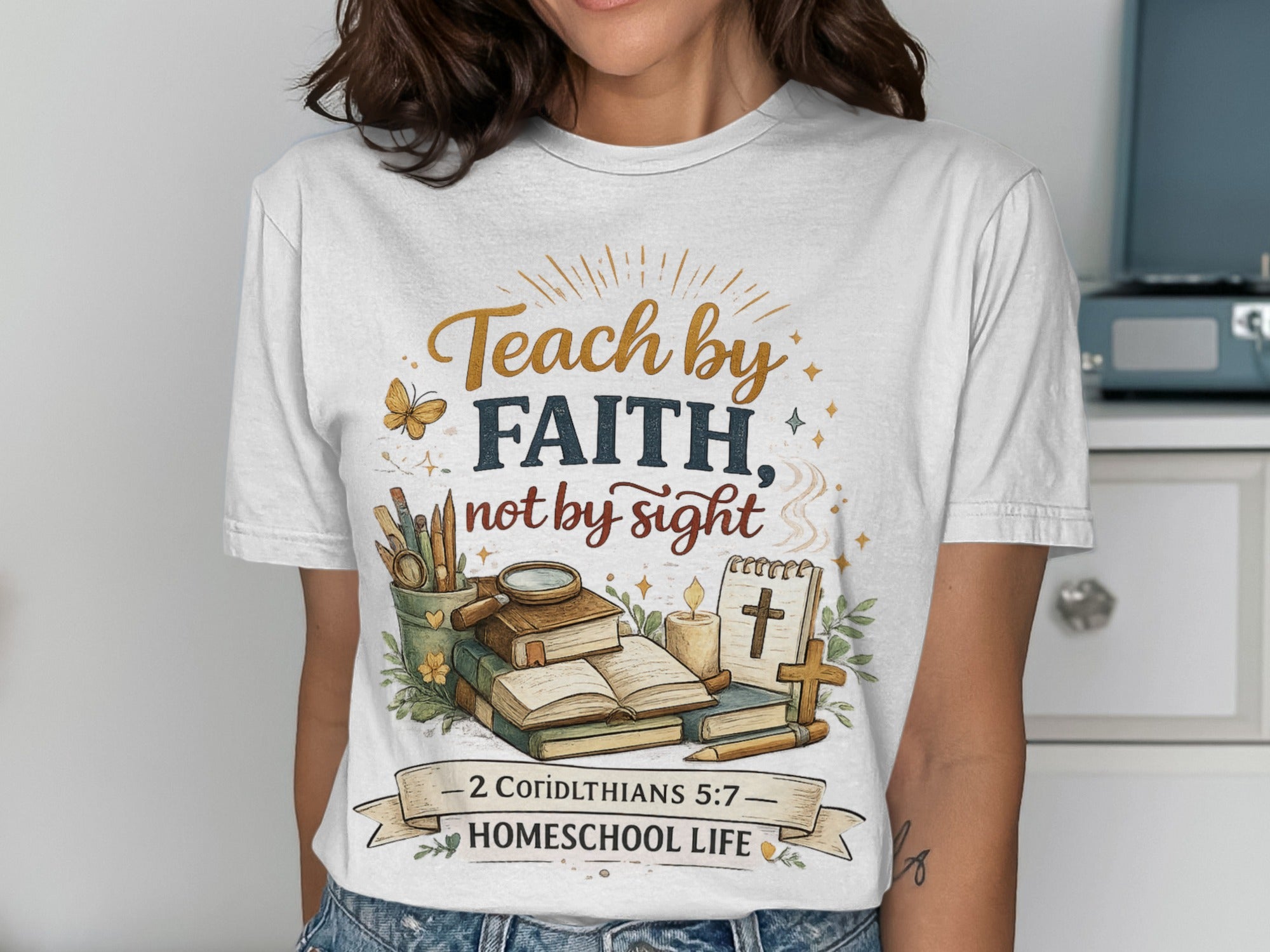 T-shirt with "Teach by Faith, Not by Sight" text, books, and cross.