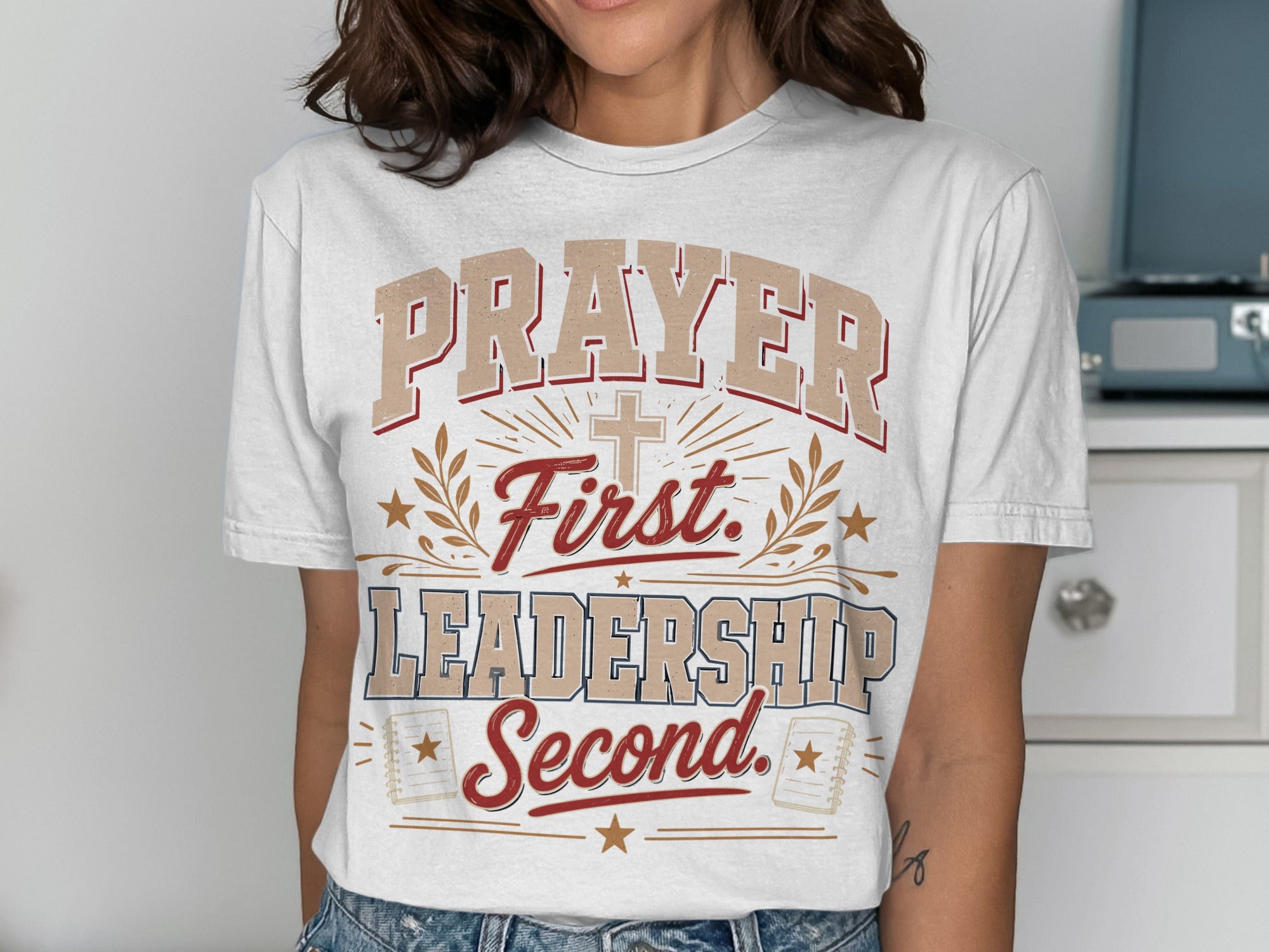White t-shirt with "Prayer First. Leadership Second." text and cross.