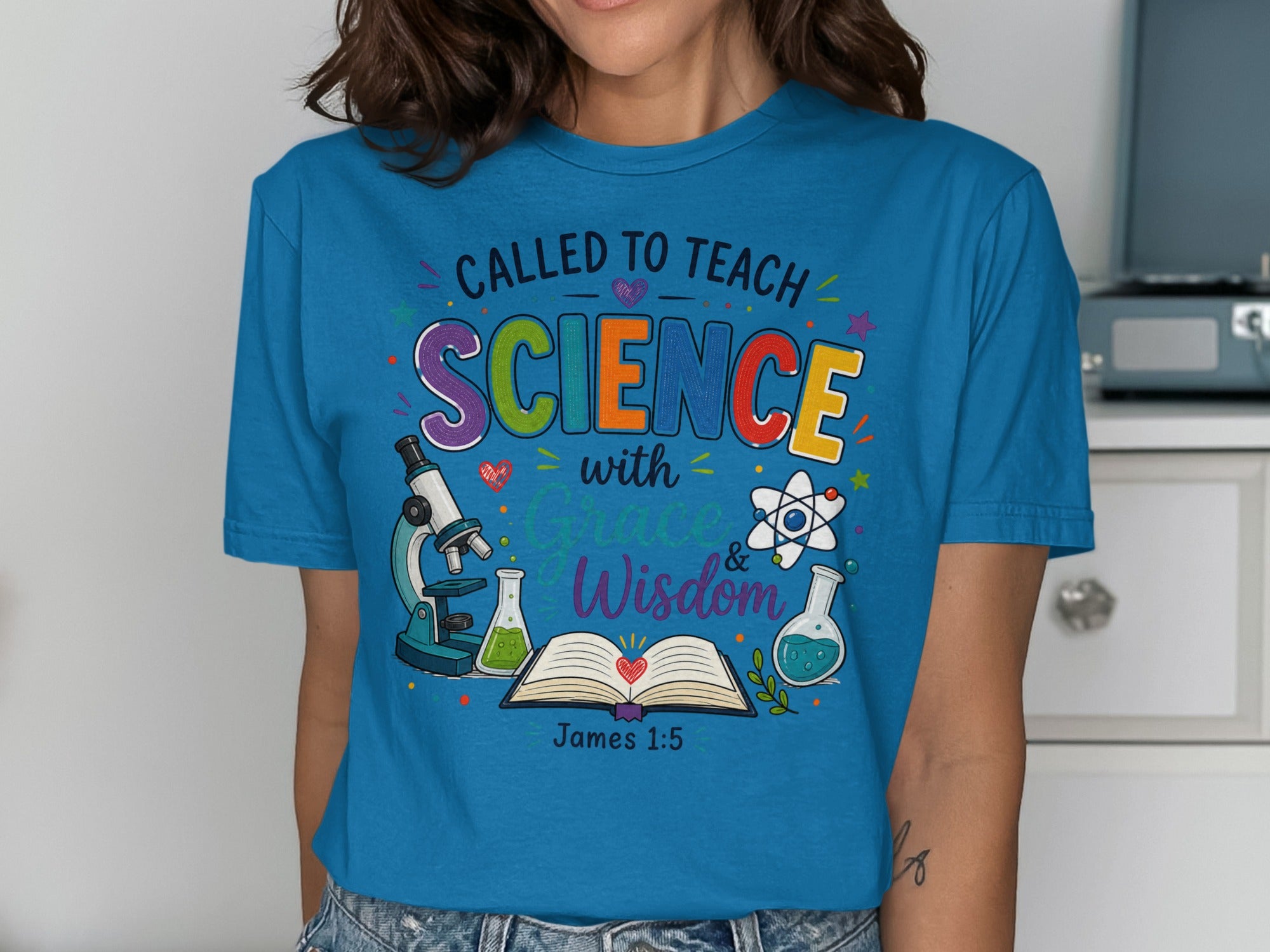 Blue t-shirt with "Called to Teach Science with Grace & Wisdom" and science icons.