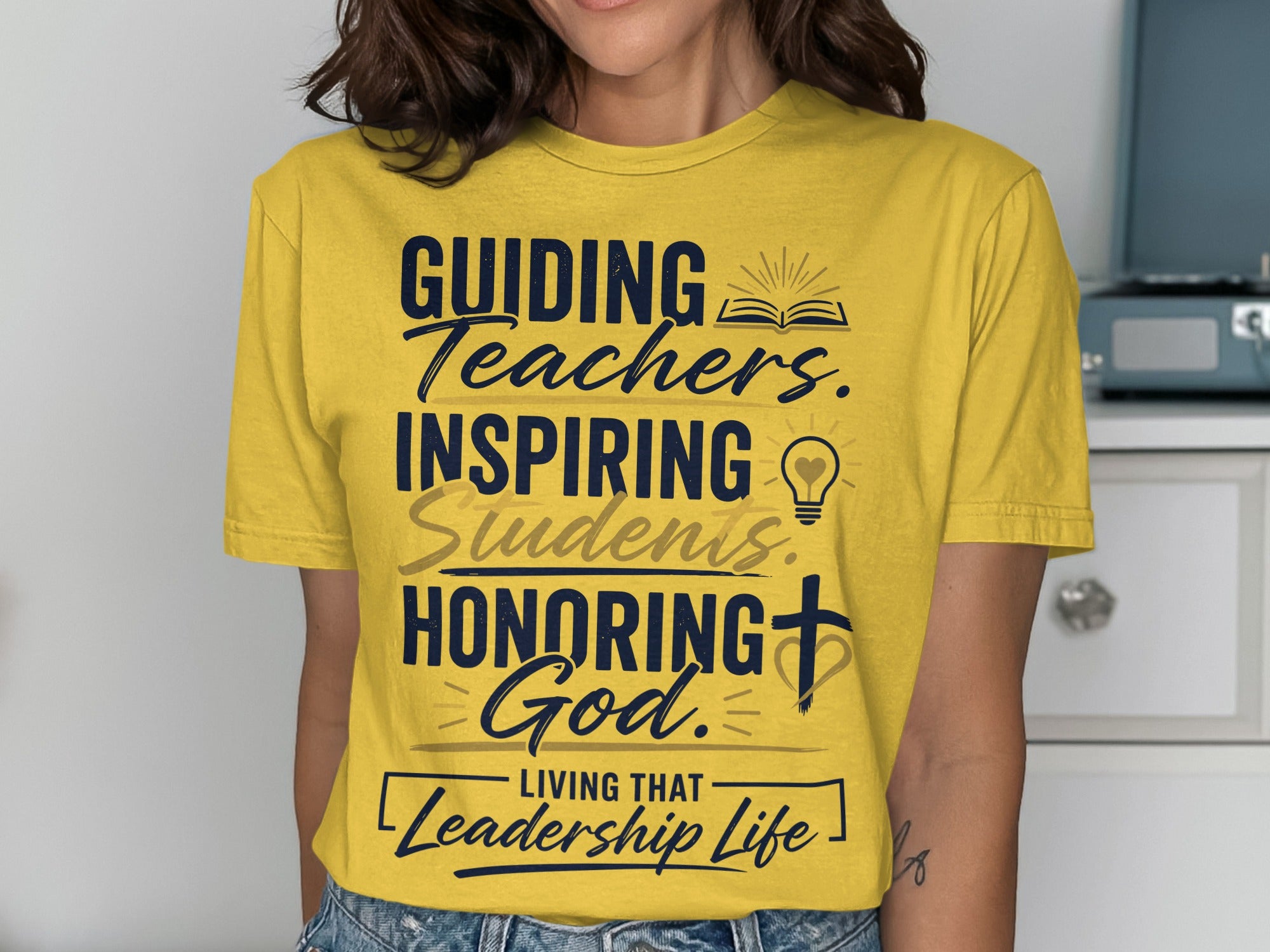 Yellow t-shirt with "Guiding Teachers, Inspiring Students, Honoring God. Living That Leadership Life" text.